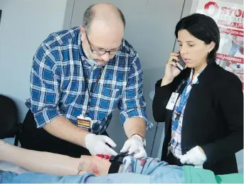  ?? JULIE OLIVER ?? Two nurses at The Ottawa Hospital — trauma co-ordinator Mathieu Lebreton, left, and injury prevention co-ordinator Sonshire Figueira — show how to apply a tourniquet. The hospital is launching a training program to help average people respond if confronted by bleeding wounds.