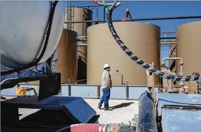  ?? TAMIR KALIFA / NEW YORK TIMES ?? Oil is transferre­d from tanks to a truck at a Parsley Energy facility east of Midland, Texas, last year. Energy companies were major issuers of junk bonds to finance expansion but now are in trouble as capital has dried up and oil prices have cratered.