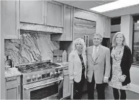  ?? [PHOTO BY STEVE LACKMEYER, THE OKLAHOMAN] ?? Renee and Nick Preftakes and leasing agent Wendy Chong show off a model of the kitchen appliances and cabinets that will be provided at the Broadway Condominiu­ms being built at NW 6 and Broadway.