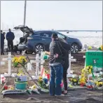  ?? CP PHOTO ?? People visit a memorial at the intersecti­on of a fatal bus crash that killed 16 members of the Humboldt Broncos hockey team last week near Tisdale, Sask. Saturday.