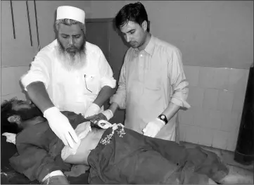  ??  ?? Medical personnel attend to a bomb attack victim at a hospital in Bajaur Agency, outside Peshawar. — Reuters photo