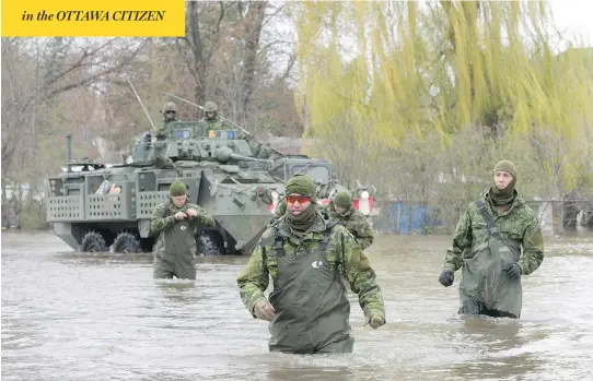  ?? RYAN REMIORZ / THE CANADIAN PRESS ?? Canadian Forces personnel wade through the flooded streets in Deux-Montagnes, Que. More than 1,500 soldiers hit the ground Monday to help Quebecers deal with flooding.