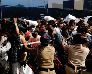  ?? Reuters ?? Police officers attempt to control a crowd at a railway station amidst the spread of the coronaviru­s disease in Mumbai on Tuesday. —