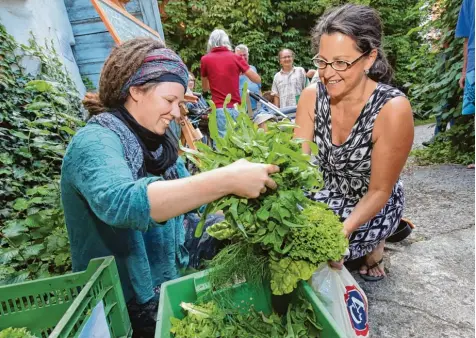  ?? Foto: Michael Hochgemuth ?? Carmen Rauh (rechts) versorgt sich wöchentlic­h an der Verteilste­lle am Oberen Graben mit einer Ration Salat und Gemüse, das Bauern aus der Augsburger Umgebung an gebaut haben. Dafür zahlen die Kunden vorab einen festen Preis. Landwirte wie Jana...