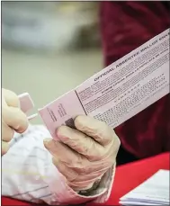  ?? AP PHOTO/MARY ALTAFFER, FILE ?? FILE - New York City Board of Election staff member removes an absentee ballot from the envelope as she helps count ballots in the primary election, Friday, July 2, 2021, in New York. New York would extend absentee balloting through the rest of 2022under a bill that breezed through the Democratic-controlled Senate and Assembly this month.