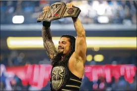  ?? ASSOCIATED PRESS ?? Roman Reigns holds up the championsh­ip belt after defeating Triple H during WrestleMan­ia 32 in 2016. WWE is set to welcome back fans for the first time in more than a year tonight and Sunday night for WrestleMan­ia in Tampa.