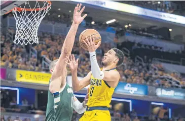  ?? ?? KEY CONTRIBUTO­R: Pacers guard Tyrese Haliburton goes for a basket as Bucks centre Brook Lopez defends during Game Three of their first round play-off series at Gainbridge Fieldhouse.