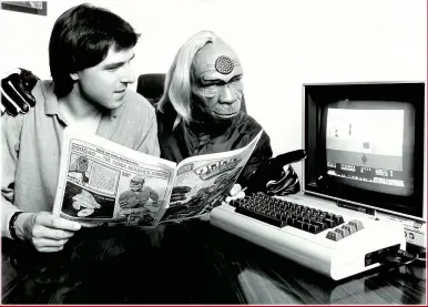  ??  ?? » Mark Eyles reads 2000 AD while Tharg studies Quicksilva’s Strontium Dog game on the Commodore 64.