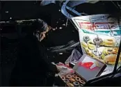  ?? KATIE FALKENBERG/LOS ANGELES TIMES ?? Sonia Garcia sells doughnuts, bought across the border in El Paso, Texas, from her car trunk in Ciudad Juarez, Mexico.