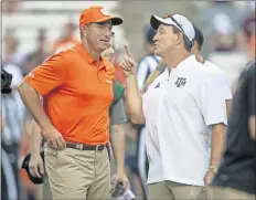  ?? [AP PHOTO/SAM CRAFT, FILE] ?? Clemson coach Dabo Swinney, left, and Texas A&M coach Jimbo Fisher talk before last season's game in College Station, Texas. Clemson won 28-26.