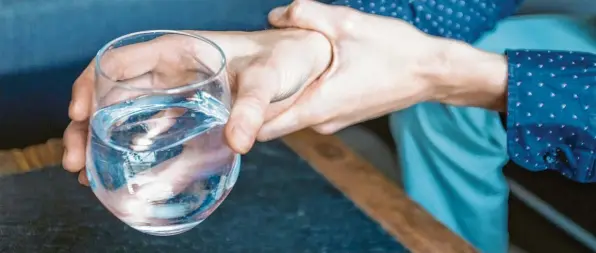  ?? Foto: Laura Ludwig, dpa ?? Um auszuloten, welche Tremorart vorliegt, können einige Tests helfen: Dazu gehört es etwa auch, ein Wasserglas zu heben.