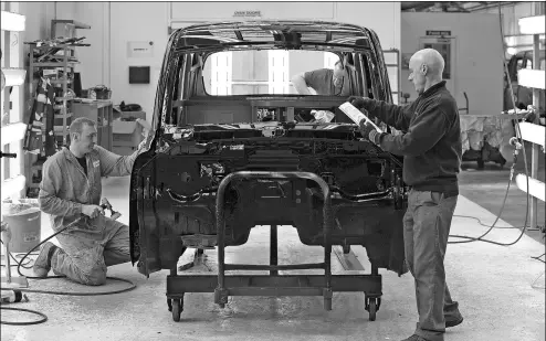  ?? BLOOMBERG VIA GETTY IMAGES ?? Employees polish a freshly painted black TX4 Euro 5 London taxi cab in the paint shop at the London Taxi Company's assembly plant, a unit of Zhejiang Geely Holding Co, in Coventry, the United Kingdom.