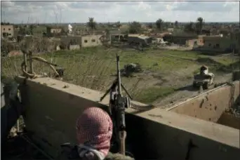  ?? FELIPE DANA — THE ASSOCIATED PRESS ?? A U.S.-backed Syrian Democratic Forces (SDF) fighter stands atop a building used as a temporary base near the last land still held by Islamic State militants in Baghouz, Syria, Monday.