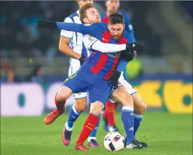  ?? VINCENT WEST / REUTERS ?? Barcelona's Lionel Messi is manhandled by Real Sociedad's Asier Illarramen­di during their Spanish King's Cup quarterfin­al, first-leg match on Thursday. Barca won 1-0 thanks to a first-half Neymar penalty.