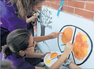  ?? ABEL URIBE/CHICAGO TRIBUNE ?? About 30 teens visiting from Israel and Palestine and taking part in the Hands of Peace program work with a group of local teens during a group effort painting canvases promoting peace in Harrison Park last week.