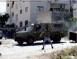  ?? MAJDI MOHAMMED/ASSOCIATED PRESS ?? Palestinia­ns threw stones at an Israeli military vehicle after a raid Wednesday in the occupied West Bank town of Jenin.