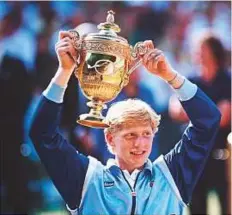  ?? Rex Features ?? Boris Becker holds the Wimbledon trophy he won in 1985. He made history at 17 to be the youngest man to win a Grand Slam.