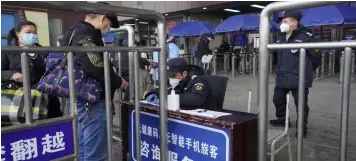  ?? MONITORING TRAVELERS. (AP Photo/Ng Han Guan) ?? Travelers are screened before entering the Wuchang train station at the start of the annual Lunar New Year travel in Wuhan in central China's Hubei province on Thursday, Jan. 28, 2021. Efforts to dissuade Chinese from traveling for Lunar New Year appeared to be working as Beijing’s main train station was largely quiet and estimates of passenger totals were smaller than in past years.