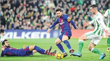  ??  ?? Barcelona's Lionel Messi (C) and Andre Gomes challenge Real Betis' Fabian Ruiz (R) during the Spanish league football match at the Benito Villamarin stadium in Sevilla on Sunday night.