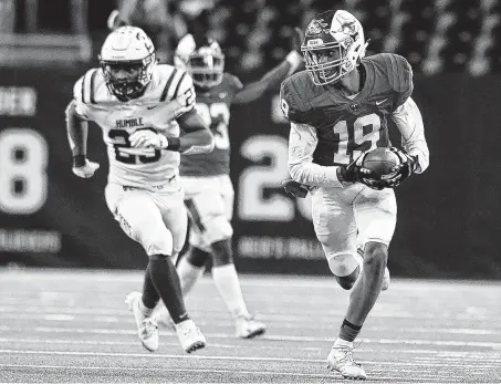  ?? Jerry Baker / Contributo­r ?? Katy Taylor defensive back Hollis Robinson (19) returns an intercepti­on against Humble in a regional semifinal game Saturday.