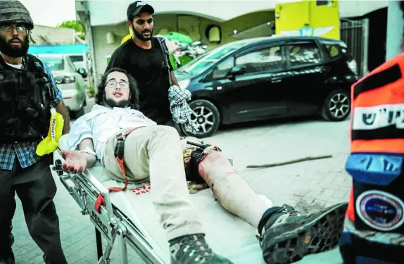  ??  ?? Paramédico­s atienden a un joven judío tiroteado en Lod
