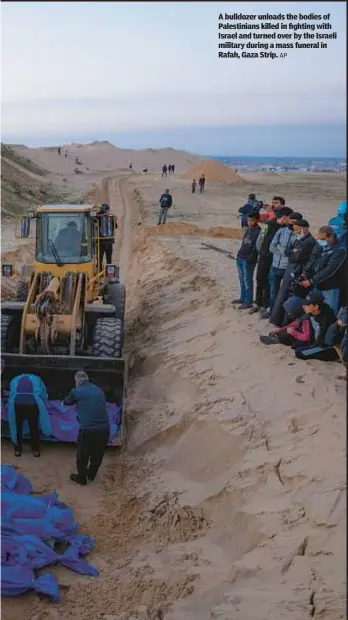  ?? AP ?? A bulldozer unloads the bodies of Palestinia­ns killed in fighting with Israel and turned over by the Israeli military during a mass funeral in Rafah, Gaza Strip.