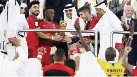  ??  ?? Qatar’s Emir Tamim bin Hamad al-Thani (centre) presents the trophy to the Duhail players following the Amir Cup final match between Al Sadd and Al Duhail at the Al Wakrah Stadium in the Qatari city of Al Wakrah. — AFP photo