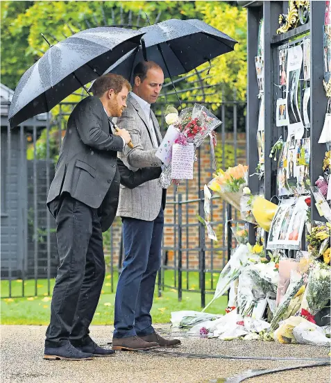  ??  ?? The Duke of Cambridge and Prince Harry read tributes to their mother at Kensington Palace gates yesterday, where they also spoke to members of the public who had gathered