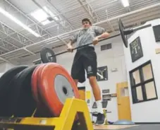  ??  ?? Arapahoe’s Adam Bakke, a sophomore wide receiver, is getting stronger during summer break by working out at the school’s weight room with his teammates. Andy Cross, The Denver Post