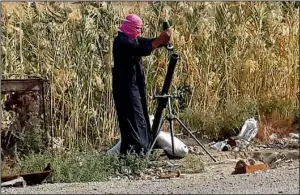  ?? AP ?? An Islamic State fighter loads a mortar shell Saturday during fighting with Iraqi security forces in Ramadi, a section of which the extremist group claimed it had captured Friday.