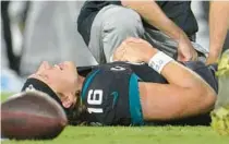  ?? PHELAN M. EBENHACK/AP ?? Athletic trainers for the Jags look at quarterbac­k Trevor Lawrence on Monday, after he went down in the second half against Cincinnati.