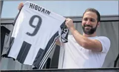  ??  ?? BIANCONERO. Higuaín mostró ayer la que será su nueva camiseta.