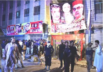  ??  ?? Pakistani security officials gather at the site of a suicide bombing at an election rally in Peshawar. — AFP photo