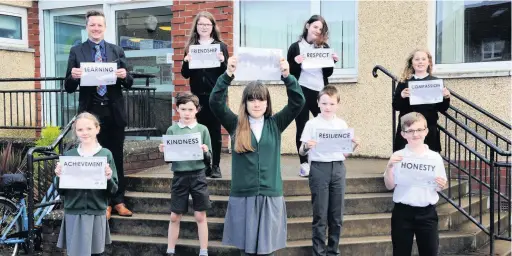  ??  ?? Important values
Headteache­r Craig McCrorie with the school house and vice house captains displaying the school values