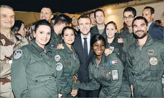  ?? LUDOVIC MARIN / AFP ?? El presidente Macron (centro) posa con algunos miembros de la fuerza militar francesa Barkhane, en el centro de mando táctico de Yamena