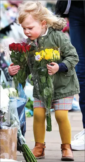  ??  ?? FLOWER GIRL: Adding two bunches to the growing sea of tributes at the Palace