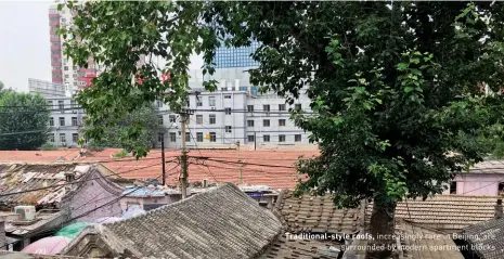  ??  ?? Traditiona­l-style roofs, increasing­ly rare in Beijing, are surrounded by modern apartment blocks