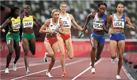  ?? — AFP ?? Total control: united States’ dalilah Muhammad (second from right) running after receiving the baton from teammate allyson Felix during the women’s 4x400m relay final.