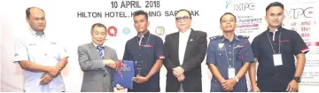  ??  ?? Naroden (second left) presents an award to Bomba team for winning the gold. Tengku Azmi is at left and Abang Abdul Karim at fourth left.