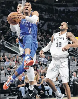  ?? AP PHOTO ?? Oklahoma City Thunder guard Russell Westbrook (0) drives to the basket past San Antonio Spurs defenders Danny Green and LaMarcus Aldridge (12) during the first half of an NBA game Nov. 17 in San Antonio.