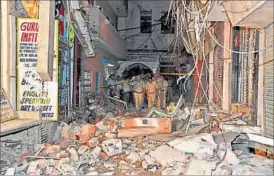  ??  ?? Police personnel inspect street number 17 of Gandhinaga­r in East Delhi, where a LPG cylinder exploded, on Monday evening. SONU MEHTA / HT PHOTO