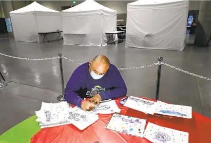  ?? K.C. ALFRED U-T ?? Martin Vasquez draws as part of an art program offered at the homeless shelter at the San Diego Convention Center. Vasquez said he was interested in art when he was younger and has occasional­ly returned to it over the years.