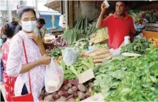  ?? — Reuters ?? A vendor sells vegetables to a customer in Colombo, Sri Lanka.