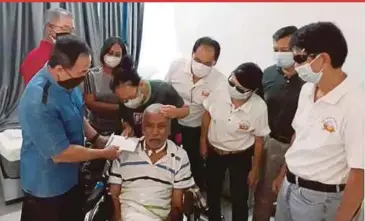  ?? BY ADRIAN DAVID PIC ?? Major-General (Rtd) Toh Choon Siang handing over a cash donation to Norlie Naji to acquire an electric patient’s hoist for Captain (Rtd) Anscelly Roy Thomas at his home in Taman Rimbun, Puchong. With them are (from left) Captain (Rtd) Steven Liew Hong Seng, Anna Anscelly, Corporal (Rtd) William Tee Kong Joo, retired able-seaman Lydia Chan, Major (Rtd) Lee Kien Mun and retired staff-sergeant Richard Lye Wah.