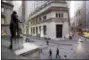  ?? MARK LENNIHAN — THE ASSOCIATED PRESS FILE ?? People walk to work on Wall Street beneath a statue of George Washington in New York.