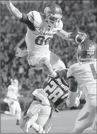  ?? Arkansas Democrat- Gazette fi le photo ?? Arkansas wide receiver Drew Morgan hurdles Mississipp­i defensive back Cameron Ordway during the fourth quarter. Morgan fi nished with 9 catches for 122 yards and 3 touchdowns, including a game- tying 9- yard score in overtime in the Razorbacks’ victory.