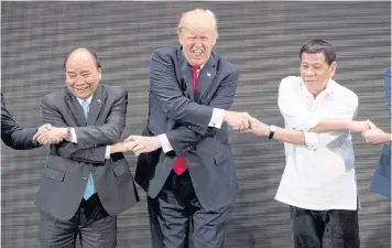  ??  ?? ALL PALS: US President Donald Trump, centre, reacts as he does the ‘Asean-way handshake’ with Vietnamese Prime Minister Nguyen Xuan Phuc, left, and Philippine President Rodrigo Duterte during the opening ceremony of the Asean Summit in Manila,...