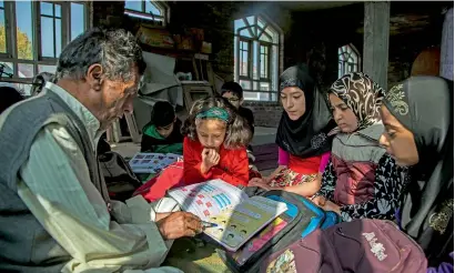  ?? AP ?? Mohammad Hussain teaches Kashmiri children at an ad hoc learning centre at a local mosque in Srinagar. —