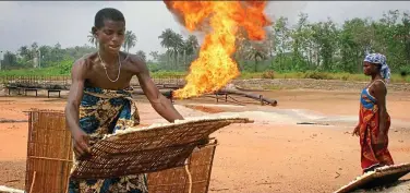  ??  ?? Hostile environmen­t: A farmer tends to crops beside an oil pipeline in the Niger Delta