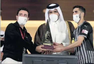  ??  ?? Xavi y el capitán del Al Sadd recogen el trofeo de campeón.